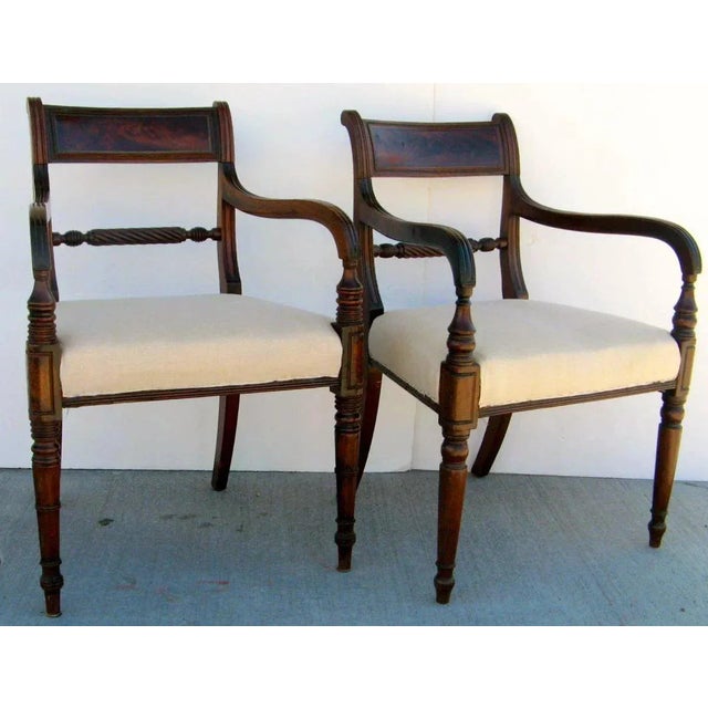 Pair of English mahogany Georgian/Regency period chair. Down swept arms that curve straight down to the turned legs. The...