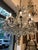 A ten-light crystal dining room chandelier, circa 1950, features a circular, square-section brass frame and ten curved...