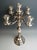 Decorative large five-light silver candelabra on a round base, with embossed and chased geometric and floral decor. Finest...