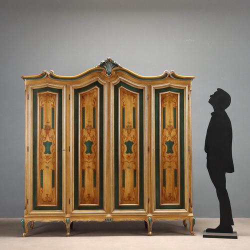 Lacquered and painted wardrobe. Four-door paneled front with floral arrangements and painted scrollwork frames, which...