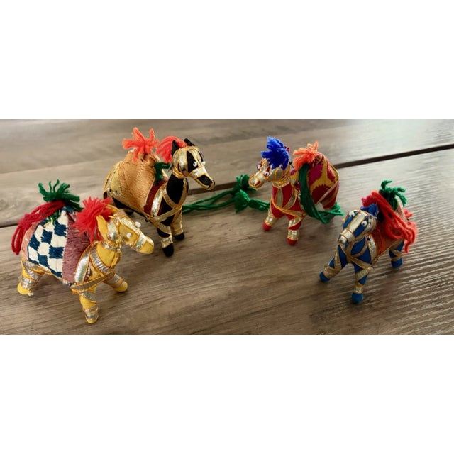 *Set of 4 decorative camel figurines *Handcrafted textile construction *Elaborately embellished with metallic trim,...