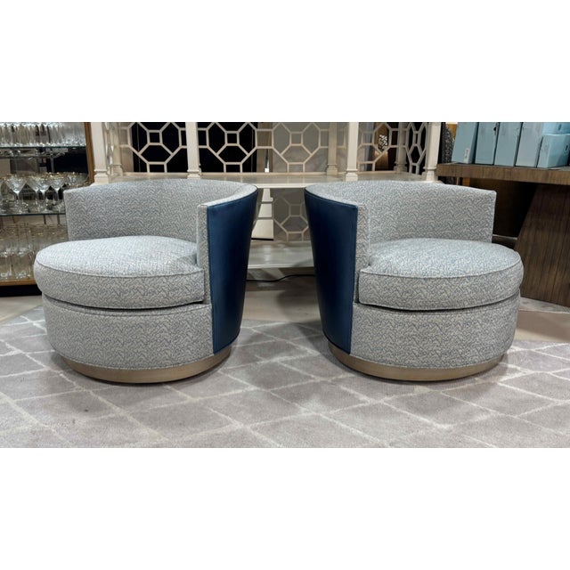 A pair of Provo swivel chairs by Kravet furniture. The 360-degree swivel chairs feature a loose seat cushion and a tight...