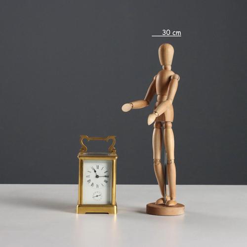 Gilded bronze travel clock with beveled glass and exposed movement. Enamelled metal dial with Roman and Arabic numerals....