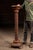 Tall freestanding carved walnut pedestal featuring a heavily ornamented column and circular display top. The base is...