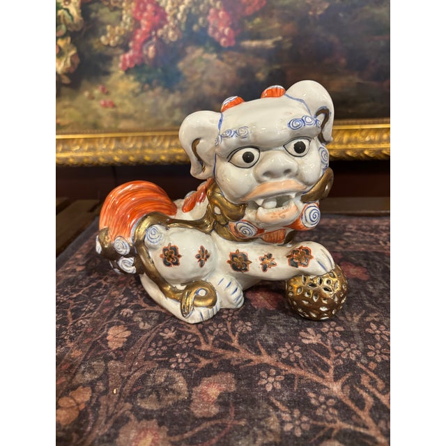 A wonderful pair of hand-painted Japanese Kutani ceramic foo dogs, or guardian lions, decorated in traditional iron red,...