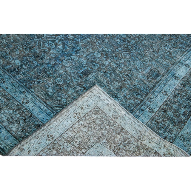 Beautiful Vintage Overdyed hand-knotted wool rug with a blue field. This Persian rug has gray frame in an all-over floral...