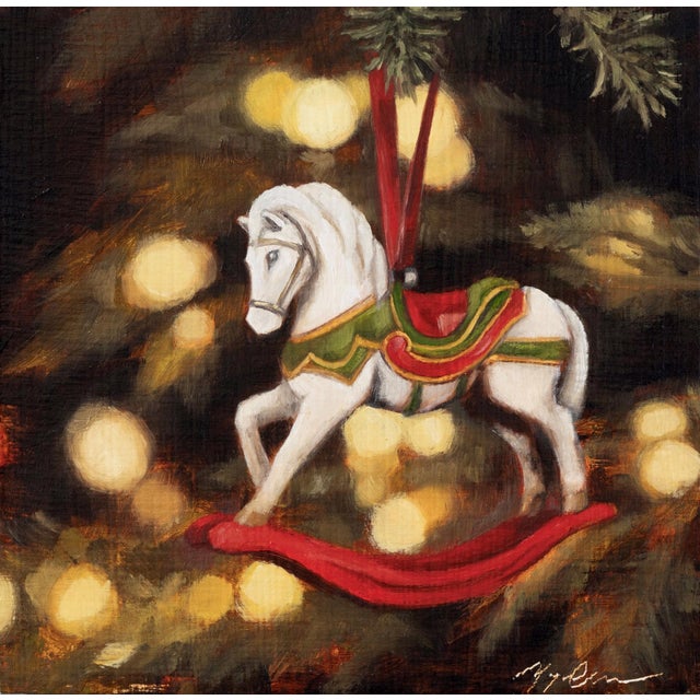 This oil on panel piece depicts a charming rocking horse ornament, delicately detailed with vibrant colors and a festive...
