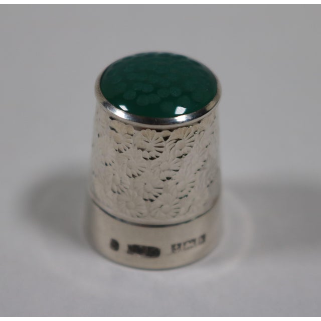 English sterling silver thimble with a glass top, featuring a beautiful floral stamped design throughout the body. It is...