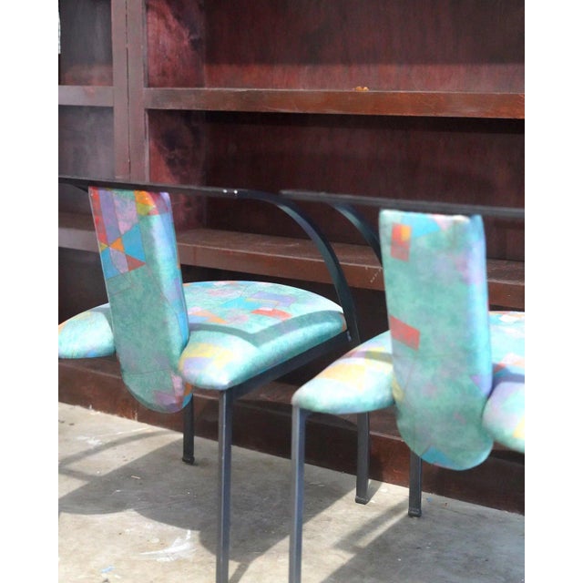 A striking pair of vintage postmodern chairs featuring sculptural black metal frames with dramatic sweeping arms and...