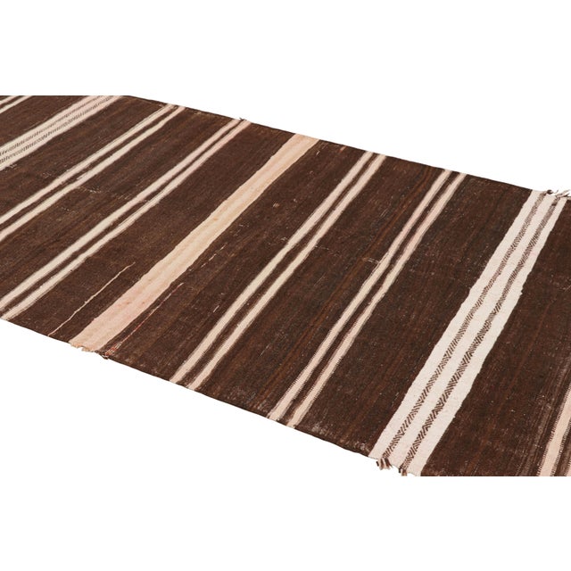 Handwoven in wool and originating from Morocco circa 1950-1960, this 4x11 vintage Moroccan Kilim and runner rug is a...