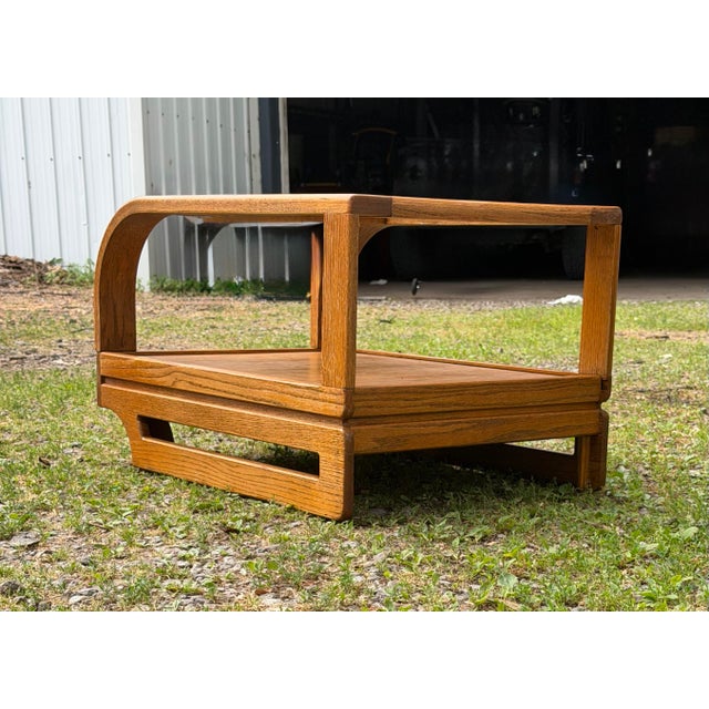 Solid oak side table is manufactured by The Stratford Company in the style of Lou Hodges. This post-modern piece has a...