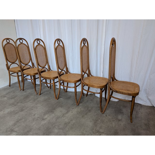 Vintage bentwood dining chair in the classic Thonet style, featuring a high cane backrest and cane seat. Made in former...