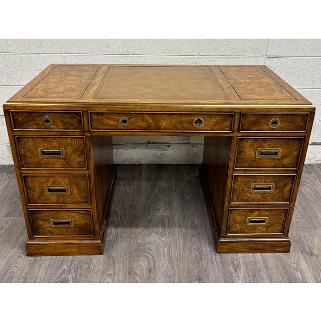 This is a gorgeous vintage Drexel “Et Cetera” burl wood Campaign style executive desk featuring a tooled leather inset...