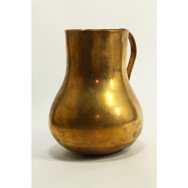 A stunning antique drinking or pouring vessel A jug or pitcher made of heavy brass, bronze, bell metal or similar copper...