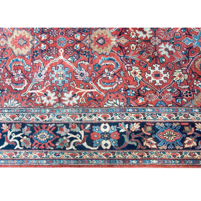 A stunning early 20th century Persian Sultanabad rug with an allover mirrored floral and scrolling vine pattern woven with...