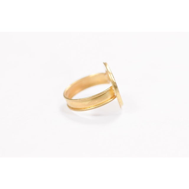A 21 karat gold ring with a bronze coin. This bronze coin is from Ancient Rome and has a profile which is well delineated....