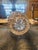 This gorgeous vase showcases frosted, hand-etched floral elements resembling flowers and detailed leaves. The frame of the...