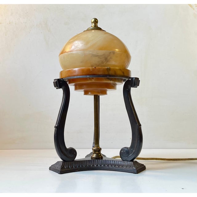 Interesting table light inspired by architectural art deco elements. It features an alabaster shade freely resting on a...