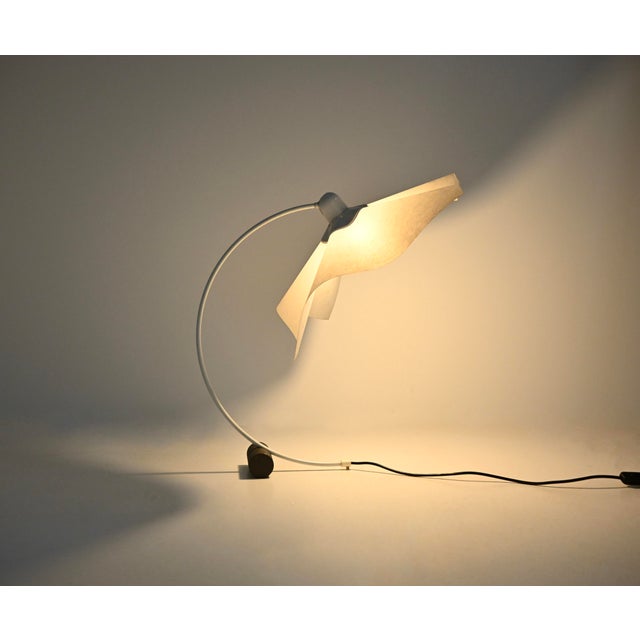 Beautiful white metal and paper table lamp by Mario Bellini. The adjustable shade allows you to direct the light in...