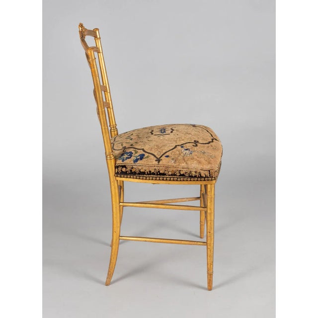 French giltwood salon side chair, the top rail centered by a carved ribboned bow and wheat sheaths, the legs and...