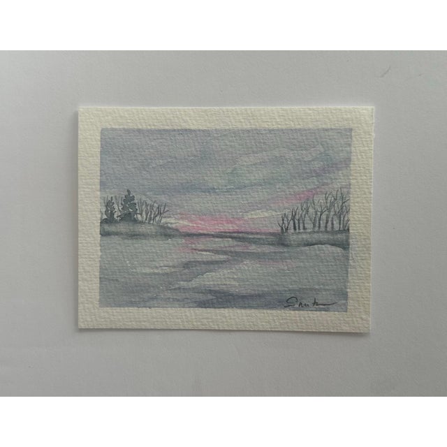 A snowy scene under gray skies with a touch of pink.