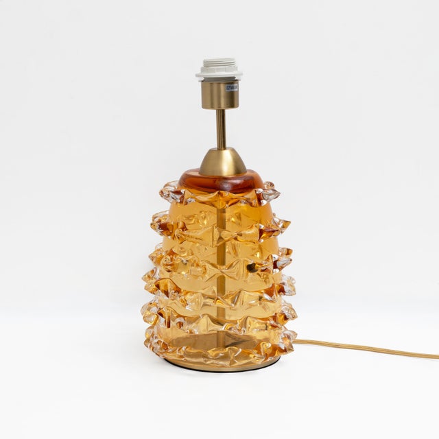 Elegant pair of table lamps featuring cylindrical bodies crafted from amber-coloured Murano glass using the refined...