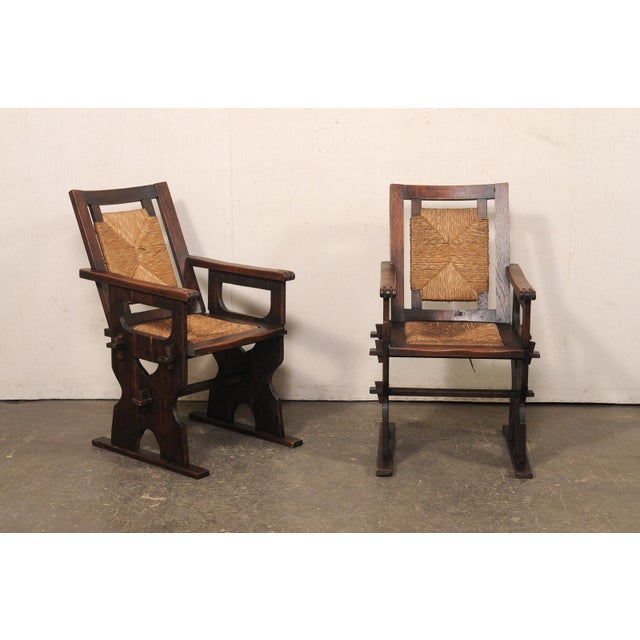 A Spanish pair of wooden armchairs with rushed back and seats from the mid 20th century. These mid-century chairs from...
