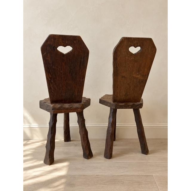 A wonderfully primitive early-20th-century set from the French Alps: two hand-carved chairs and a matching stool that...