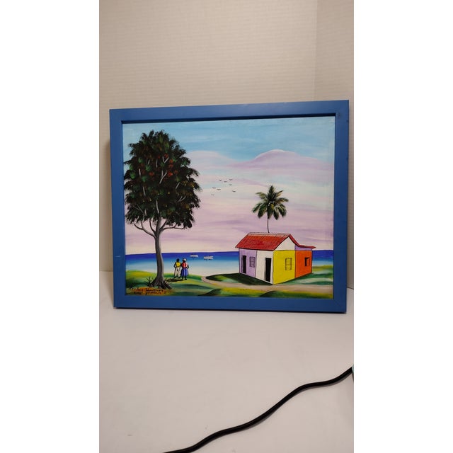 Colorful painting with a scene of the ocean, two residents, hut or house along with a tall tree. Painting signed in the...