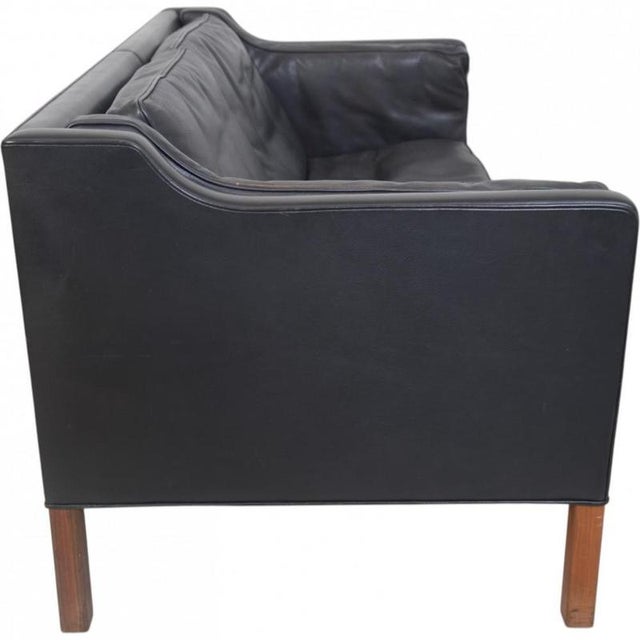 Børge Mogensen 2212 2.seater sofa upholstered in black leather and with legs of teak. The sofa is from the 1980s and...
