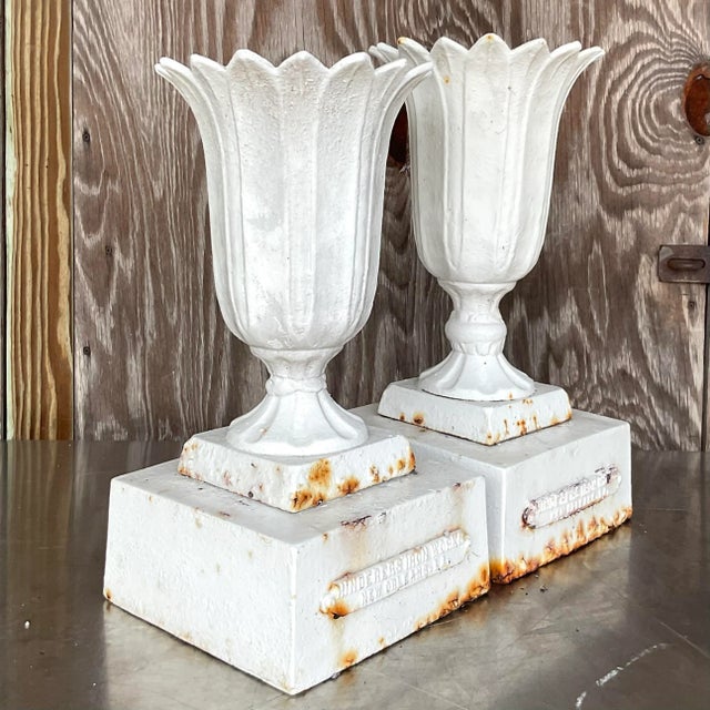 A fabulous set of two vintage urns. Made from a heavy case iron and painted white. An all over patinated rusty finish from...