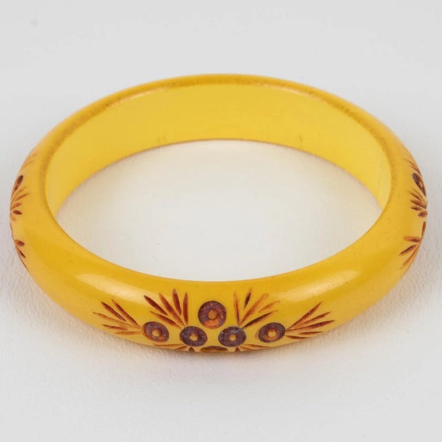 Lovely Bakelite bracelet bangle. Chunky domed shape with stylized floral carving all around and contrasting color. The...