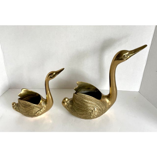 This charming pair of later mid-century brass swans brings a touch of classic Hollywood Regency glam and whimsy to any...
