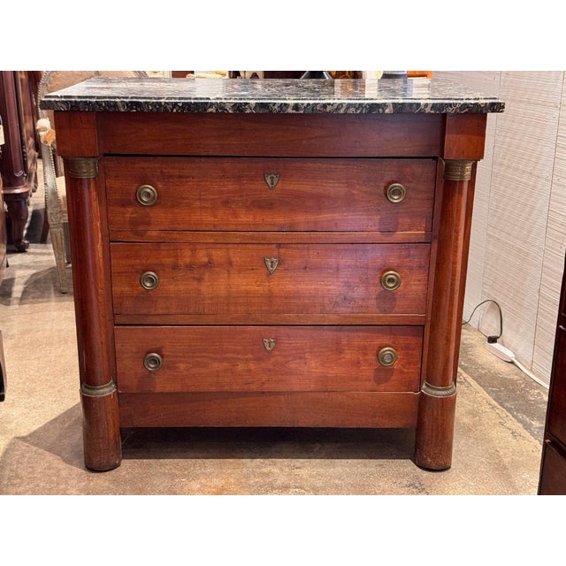 19th century French Empire commode with a molded gray marble top over three drawers, flanked by full columns with brass...