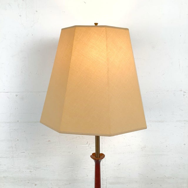 This vintage Mid-Century Modern floor lamp features a sculptural blend of warm walnut and patinated metal, creating a...