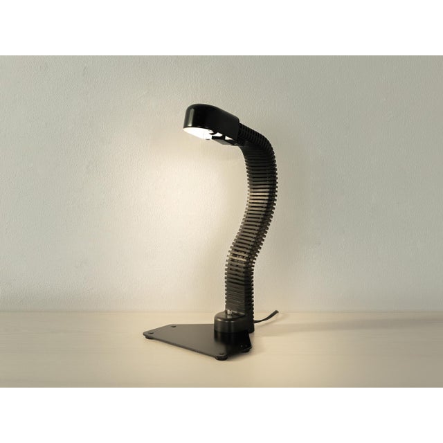 Elegant COBRA desk lamp by Kisho Kurokawa for Yamagiwa from the 1970s. Black painted metal base with a flexible, plastic-...