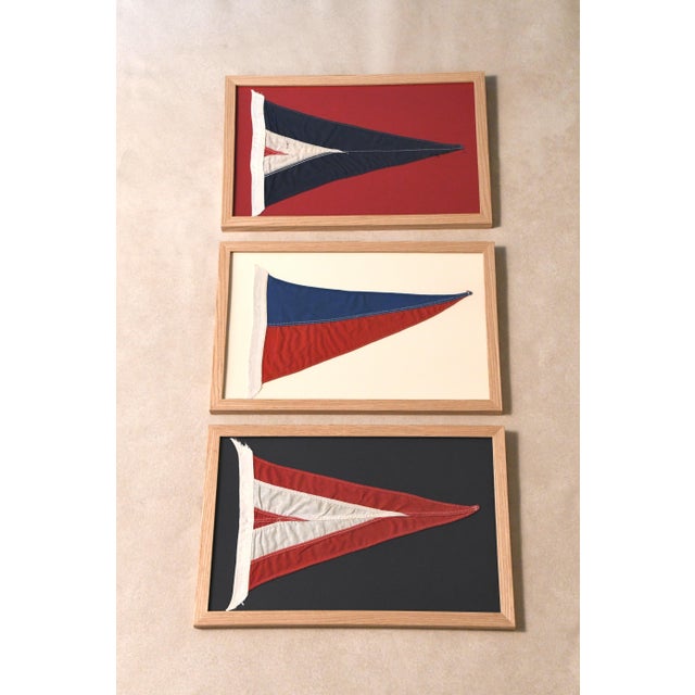 Vintage triangular yacht club burgees mounted on a contrasting ground and framed in new natural oak frames.