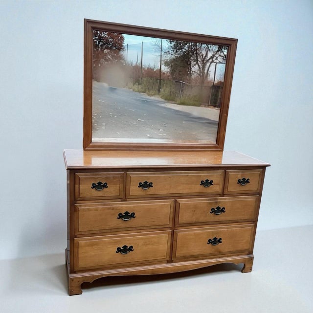 Add a touch of warm, timeless charm to your bedroom with this beautifully preserved vintage maple dresser and mirror set...