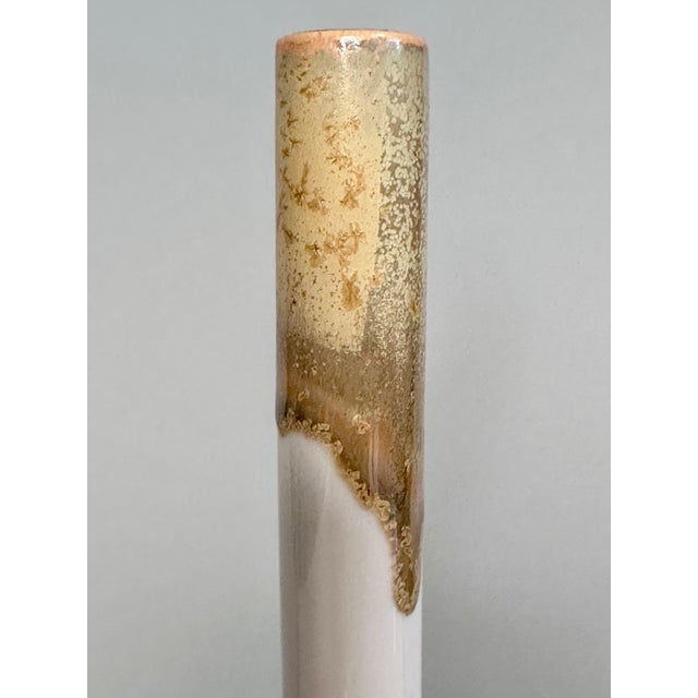 A long-necked ceramic vase decorated with a gold-ochre-brown crystalline overlay glaze. The elegant design of vase number...