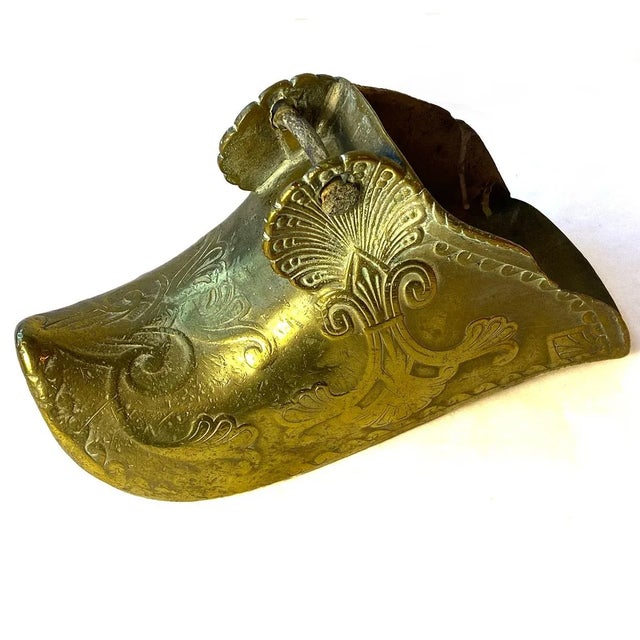 DETAILS A single, antique patinated solid brass, horse riding shoe or slipper stirrup decorated with anthemion shell and...
