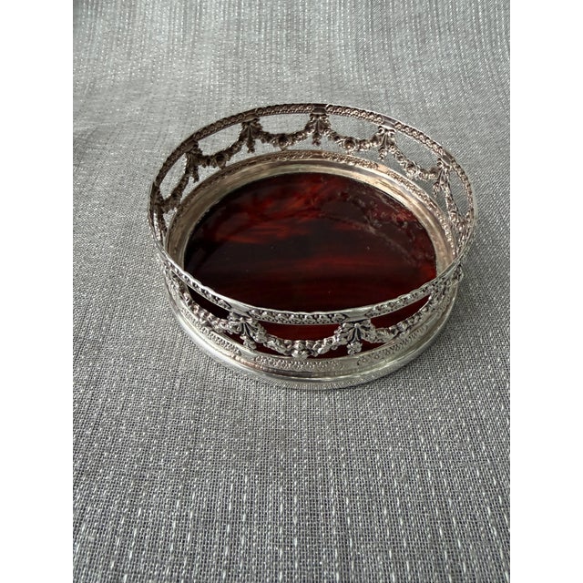Vintage silver plate wine coaster with a fine ornate draped open design along the side and a faux tortoise base. Good...