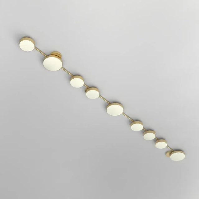 Long line, 9 circles, ceiling light by atelier areti dimensions: d 15.3 x w 279 x h 6 cm. Materials: brushed brass, white...