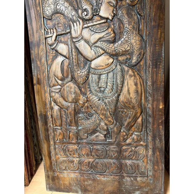 This Krishna Carved Wall Panel Sliding Barn Door. Handcrafted from reclaimed wood, this exquisite piece features an...