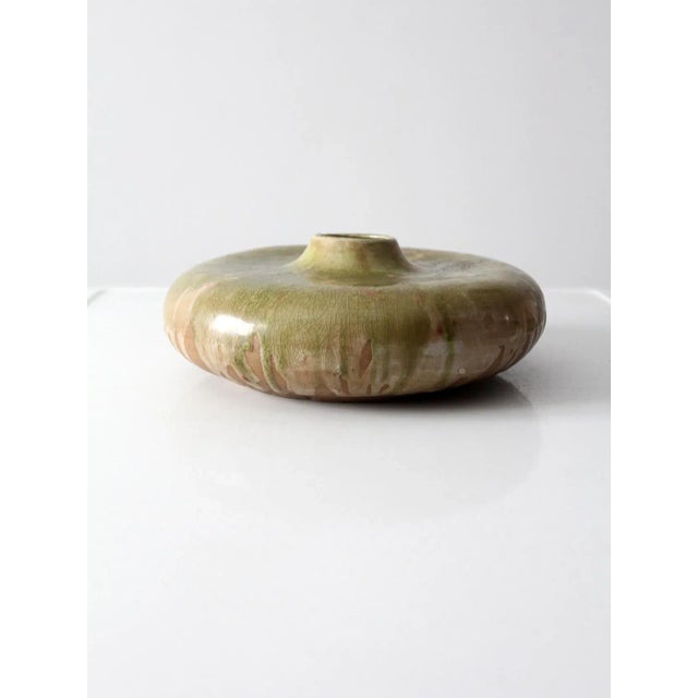A striking vintage ceramic vase with a sculptural flattened disc silhouette and a short bottle neck that creates a bold,...