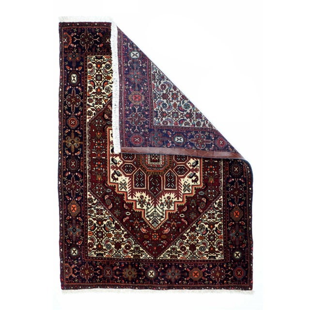 This west Persian village scatter with the characteristic navy octofoil and cartouche border, is in the typical Heriz...