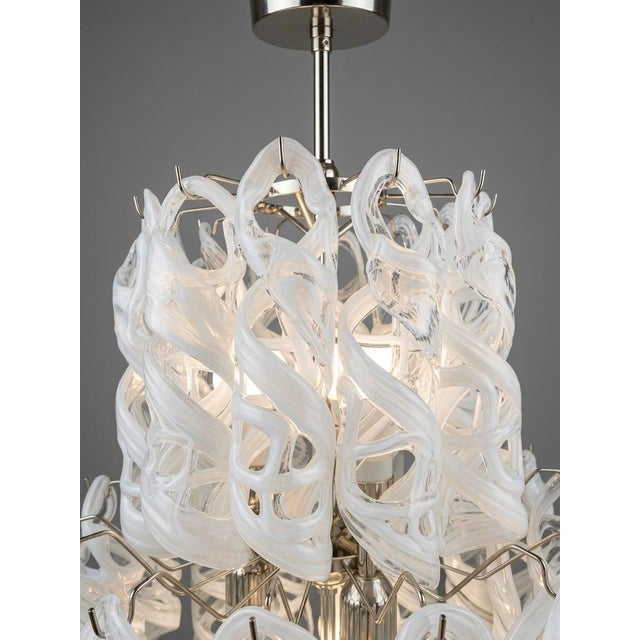 An elegant and sculptural Murano glass waterfall chandelier, attributed to Vistosi, featuring seven lights arranged within...