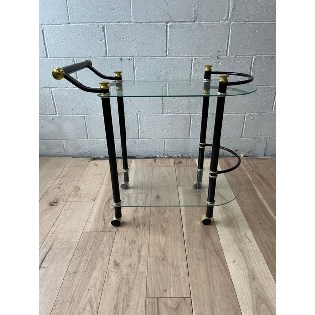 Elegant Postmodern rolling bar cart dating to the 1980s, featuring a sculptural black lacquered tubular-metal frame...