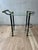 Elegant Postmodern rolling bar cart dating to the 1980s, featuring a sculptural black lacquered tubular-metal frame...