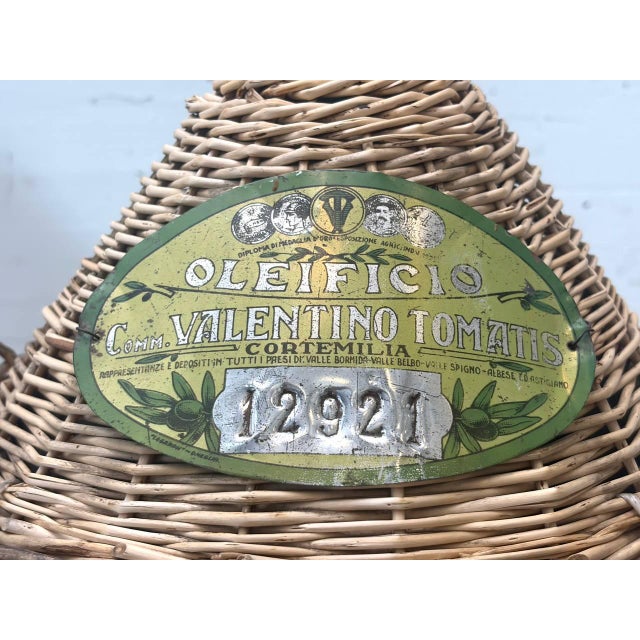 Decorative Italian glass demijohn made of mouth-blown green glass with an original wicker basket. These large glass...