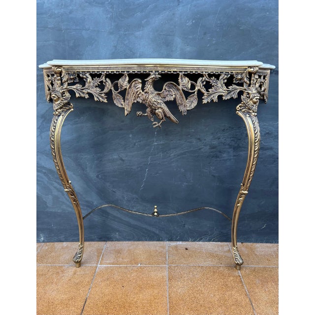 Exceptional neoclassical style console table crafted in gilt bronze with a marble top, dating to the mid-20th century. The...